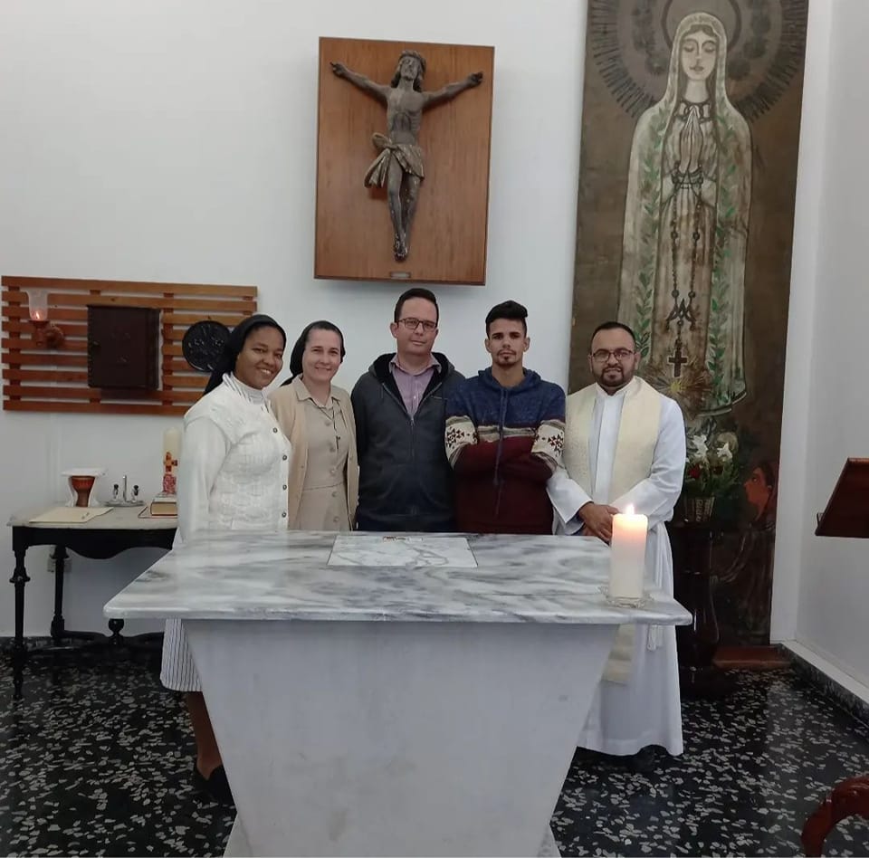 Two nuns, a priest, and two men in casual clothes posing together