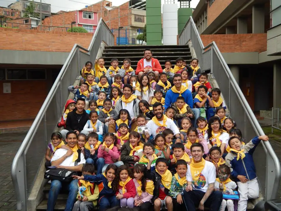 A large group of children posing on the steps of a building