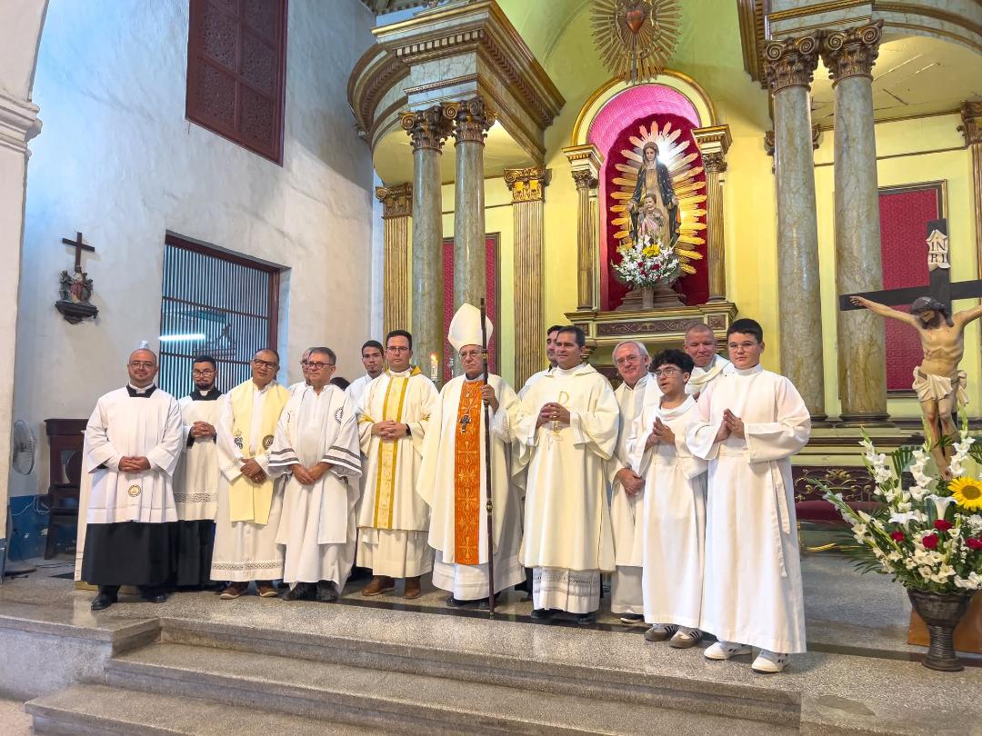 Group in white robes posing at ornate altar